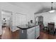 Bright kitchen with gray cabinets, center island, and hardwood flooring open to the living spaces at 4505 Woodlawn Dr, Raleigh, NC 27616