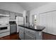 Gray kitchen featuring a center island, stainless appliances, hardwood floors, and ample storage at 4505 Woodlawn Dr, Raleigh, NC 27616