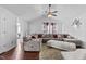 Cozy living room featuring a plush sectional sofa, hardwood flooring, and a ceiling fan at 4505 Woodlawn Dr, Raleigh, NC 27616
