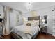 Elegant main bedroom with chandelier, plush bedding, and hardwood floors at 4505 Woodlawn Dr, Raleigh, NC 27616