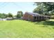 Spacious backyard with lush lawn and brick home in background at 521 S Lombard St, Clayton, NC 27520