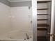 Spacious tiled bathtub shower area with built in shelves for storage at 521 S Lombard St, Clayton, NC 27520
