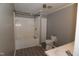 Bright bathroom featuring a tiled tub and shower, toilet, and vanity at 521 S Lombard St, Clayton, NC 27520