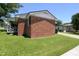 Side view of home with a brick facade, lawn, and paved driveway at 521 S Lombard St, Clayton, NC 27520