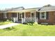 Lovely brick home featuring a charming front porch and beautifully manicured front lawn at 521 S Lombard St, Clayton, NC 27520