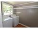 Functional laundry room equipped with washer, dryer, and built-in shelving at 521 S Lombard St, Clayton, NC 27520