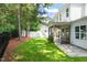Well-maintained backyard featuring lush green grass, a screened porch, and a patio at 525 Kings Lake Way, Durham, NC 27703