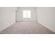 Expansive bedroom featuring neutral carpeting, white walls, and natural light from a window at 525 Kings Lake Way, Durham, NC 27703