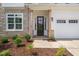 Charming front entrance with stone accents, a black front door and manicured landscaping at 525 Kings Lake Way, Durham, NC 27703