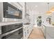Bright kitchen features stainless appliances, white cabinets, a center island with sink and marble countertops and backsplash at 525 Kings Lake Way, Durham, NC 27703