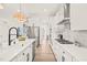 Bright kitchen features stainless appliances, white cabinets, a center island with sink and marble countertops and backsplash at 525 Kings Lake Way, Durham, NC 27703