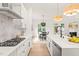 Bright kitchen features stainless appliances, white cabinets, a center island with sink and marble countertops and backsplash at 525 Kings Lake Way, Durham, NC 27703