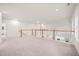 Expansive loft area with carpeting, white walls, and a staircase with light wood railings at 525 Kings Lake Way, Durham, NC 27703