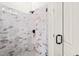 Walk-in shower features sleek glass doors and elegant marble-style tiling at 525 Kings Lake Way, Durham, NC 27703