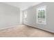Bright bedroom with neutral carpet, two large windows, and natural light at 5309 Neuse Wood Dr, Raleigh, NC 27616