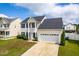 Charming two-story home with attached two-car garage, well-maintained lawn, and manicured shrubbery at 5309 Neuse Wood Dr, Raleigh, NC 27616