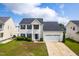 Charming two-story home with attached two-car garage, well-maintained lawn, and manicured shrubbery at 5309 Neuse Wood Dr, Raleigh, NC 27616