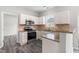 Modern kitchen boasts white cabinets, granite counters, stainless appliances, and stylish backsplash at 5309 Neuse Wood Dr, Raleigh, NC 27616