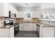 Well-equipped kitchen features granite countertops, white cabinetry, stainless steel appliances, and tile backsplash at 5309 Neuse Wood Dr, Raleigh, NC 27616