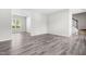 Spacious living area with neutral walls, modern laminate flooring, and a doorway to another room at 5309 Neuse Wood Dr, Raleigh, NC 27616
