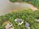 Stunning aerial view of the waterfront home surrounded by lush greenery and a serene lake at 5317 Moonflower Ct, Holly Springs, NC 27540