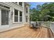 Charming back deck with wood flooring, outdoor furniture, and lush landscaping for entertaining at 5317 Moonflower Ct, Holly Springs, NC 27540