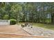 Spacious backyard with a stone patio, deck, and lush landscaping for outdoor entertaining and relaxation at 5317 Moonflower Ct, Holly Springs, NC 27540