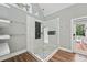 Bright bathroom with a walk-in glass shower, wooden floors, and access to the outdoor deck at 5317 Moonflower Ct, Holly Springs, NC 27540