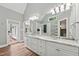 Spacious bathroom featuring double sinks with granite countertops and a large mirror with modern lighting at 5317 Moonflower Ct, Holly Springs, NC 27540