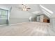 Spacious bonus room featuring plush carpeting, a ceiling fan, and ample natural light from the window at 5317 Moonflower Ct, Holly Springs, NC 27540