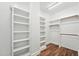 Bright, empty closet with shelving on both sides, perfect for organizing clothes and accessories at 5317 Moonflower Ct, Holly Springs, NC 27540