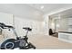 Neutral carpeted exercise room featuring weights, fan, double doors and counter at 5317 Moonflower Ct, Holly Springs, NC 27540