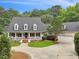 Beautiful home with a large front porch, mature trees, well-kept lawn, and an extended driveway leading to a garage at 5317 Moonflower Ct, Holly Springs, NC 27540