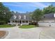 Inviting home with a classic front porch, green lawn, and curved driveway leading to a detached garage and additional parking at 5317 Moonflower Ct, Holly Springs, NC 27540