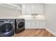 Modern laundry room with front load washer and dryer and white cabinets at 5317 Moonflower Ct, Holly Springs, NC 27540