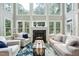 Living room features a fireplace, large windows, wood floors, and comfortable seating at 5317 Moonflower Ct, Holly Springs, NC 27540