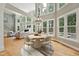Bright living room boasts large windows, hardwood floors, fireplace and a dining area with a round table at 5317 Moonflower Ct, Holly Springs, NC 27540