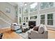 Bright living room featuring a fireplace, lots of windows, hardwood floors, and comfortable seating at 5317 Moonflower Ct, Holly Springs, NC 27540