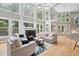 Spacious living room with a fireplace, large windows, wood floors, and comfortable seating at 5317 Moonflower Ct, Holly Springs, NC 27540