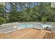 Backyard showcasing an inviting in-ground pool surrounded by a white fence and a wooden deck at 5317 Moonflower Ct, Holly Springs, NC 27540
