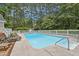 Inviting in-ground pool surrounded by lounge chairs, set within a private fenced yard at 5317 Moonflower Ct, Holly Springs, NC 27540