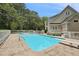 Beautiful in-ground pool with a diving board, surrounded by a fenced yard and lush greenery at 5317 Moonflower Ct, Holly Springs, NC 27540