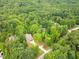 Aerial view of a home surrounded by a dense forest canopy and lush landscaping at 5504 Earle Road, Raleigh, NC 27606