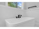 Modern bathroom with a stand-alone tub, modern fixtures, and a view to the backyard at 5504 Earle Road, Raleigh, NC 27606