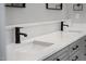 Close up of double vanity featuring quartz counters, grey cabinets, and updated fixtures at 5504 Earle Road, Raleigh, NC 27606