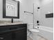 Modern bathroom with a black vanity, granite countertop, a tub and shower with tiled walls at 5504 Earle Road, Raleigh, NC 27606