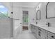 Stylish bathroom with double vanity, quartz counters, walk-in shower, and access to main bedroom at 5504 Earle Road, Raleigh, NC 27606
