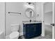 Updated bathroom with custom vanity, round mirror, and modern lighting at 5504 Earle Road, Raleigh, NC 27606