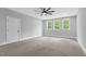 Bedroom showcasing three large windows and a modern ceiling fan at 5504 Earle Road, Raleigh, NC 27606
