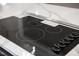 Close-up of the electric cooktop on the kitchen island, set in white quartz countertops and modern design at 5504 Earle Road, Raleigh, NC 27606
